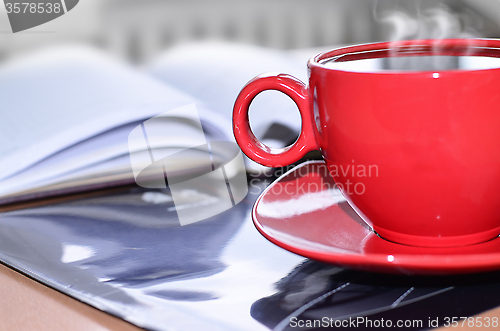 Image of Red cup of coffee on the desk in the office