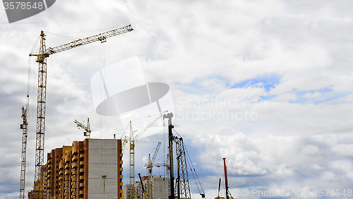 Image of Cranes and building construction on the background of clouds