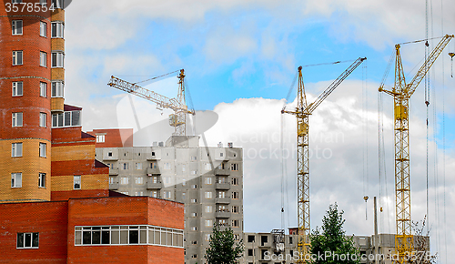 Image of Cranes and building construction on the background of clouds