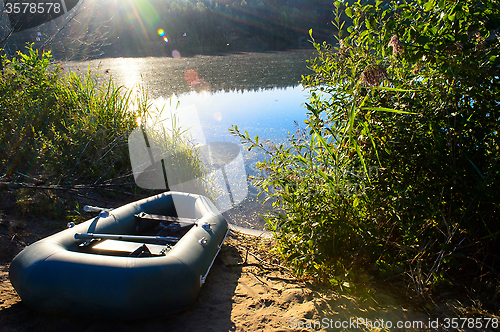 Image of Fishing boat on the river in the rays of dawn
