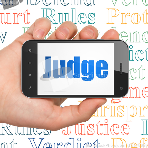 Image of Law concept: Hand Holding Smartphone with Judge on display