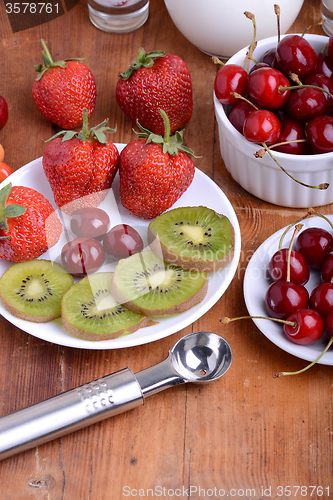 Image of fruit with cherry, strawberry, kiwi on wooden plate