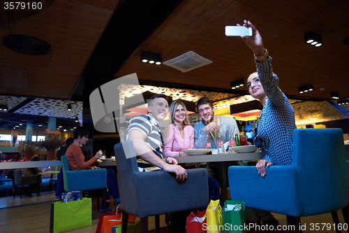 Image of friends have lanch break in shopping mall