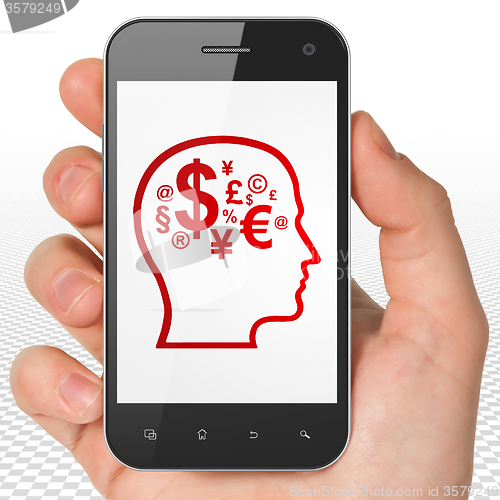 Image of Education concept: Hand Holding Smartphone with Head With Finance Symbol on display