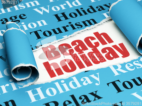 Image of Travel concept: red text Beach Holiday under the piece of  torn paper