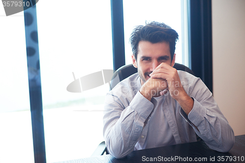 Image of relaxed young man drink first morning coffee withh rain drops on