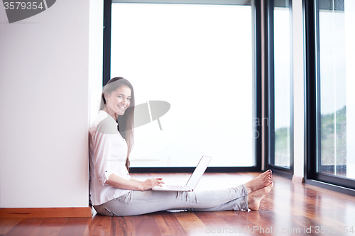 Image of relaxed young woman at home working on laptop computer