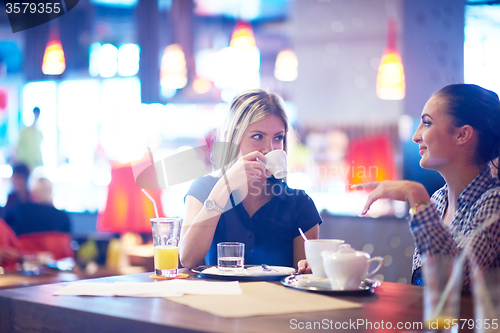 Image of girls have cup of coffee in restaurant