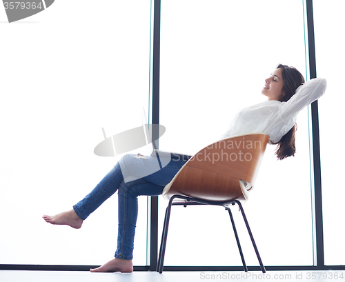 Image of relaxed young woman at home working on laptop computer