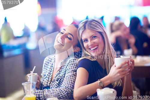 Image of girls have cup of coffee in restaurant