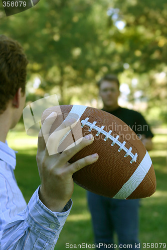 Image of Two men throwing the football