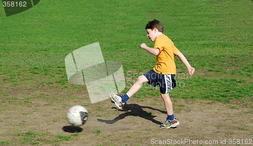 Image of Boy kicking soccer ball