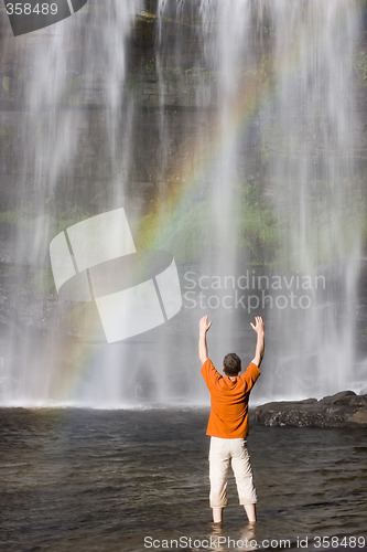 Image of Man and waterfall with rainbow