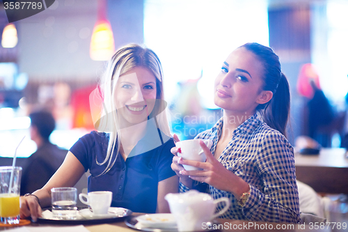 Image of girls have cup of coffee in restaurant