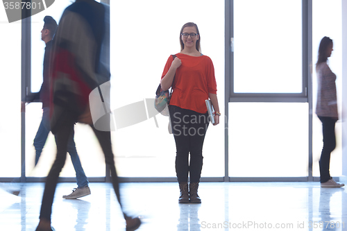 Image of student girl standing with laptop, people group passing by