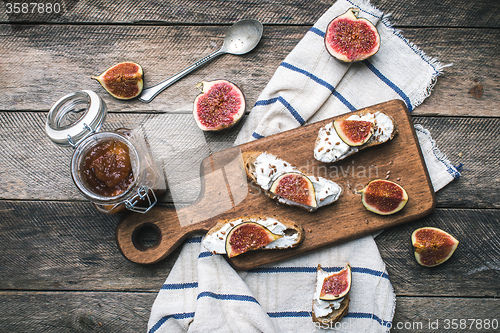 Image of rustic style food snaks with jam and figs on napkin