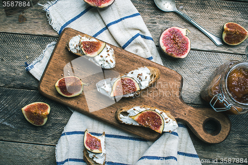 Image of rustic style healthy snacks with cut figs on napkin