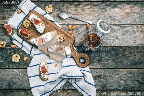 Image of snacks with cheese jam and figs on wood