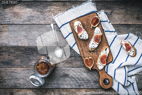Image of Healthy snacks with cheese and figs on wood board