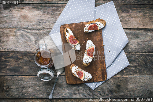 Image of rustic style Bruschetta snack with jam and figs on napkin