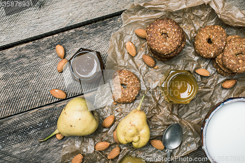 Image of Pears nuts Cookies and milk on rustic wood