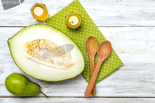 Image of green pear Healthy melon and honey on rustic wood