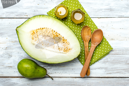 Image of Ripe melon honey and pear on white wood