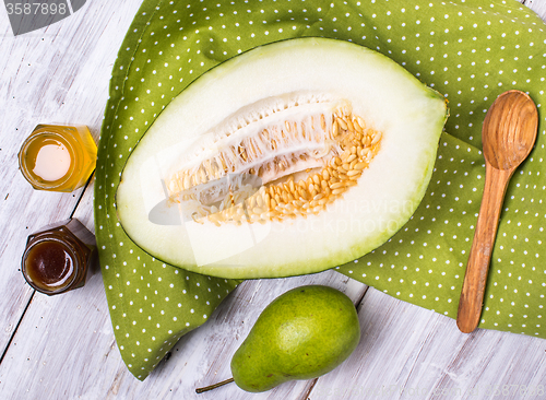 Image of Tasty melon with honey and pears on napkin