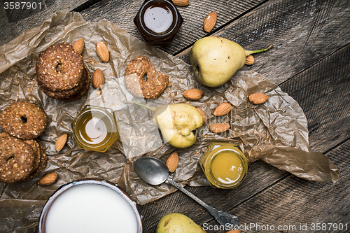 Image of Healthy Pears almonds Cookies and milk on rustic wood