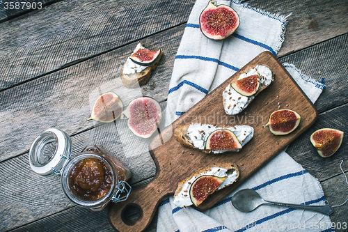 Image of rustic style snacks with jam cheese and figs on wood board