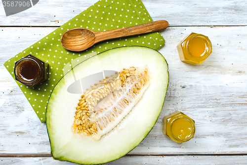 Image of Cut melon with honey on napkin and rustic board