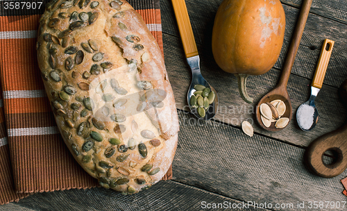 Image of pumpkin with bread and seeds on Rustic wood