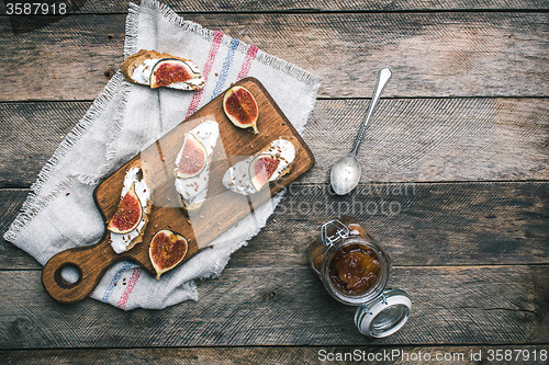 Image of Bruschetta snacks with jam and figs on napkin