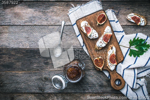 Image of tasty Snacks with cheese jam and figs on wood