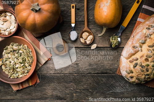 Image of Rustic pumpkins with bread and seeds on wood