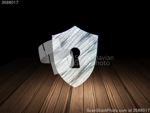 Image of Security concept: Shield With Keyhole in grunge dark room