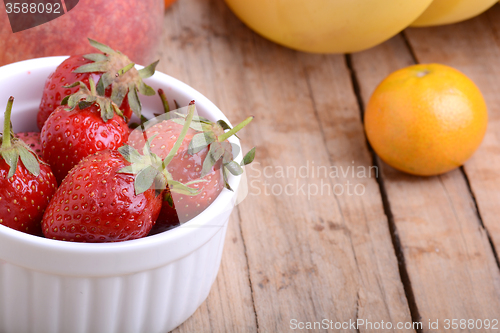 Image of Bananas apple mandarin peach strawberry on wooden background as health food concept