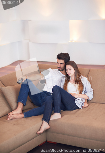 Image of young couple watching tv at home