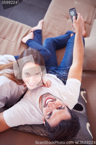 Image of young couple watching tv at home