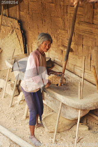 Image of Old woman grinding grain in Nagaland, India