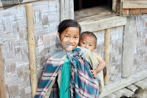 Image of Smiling older sister carrying kids in Nagaland, India
