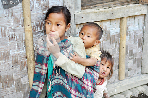 Image of Older sister carrying kids in Nagaland, India