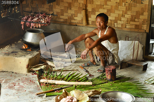 Image of Man cooking meat in Nagaland, India