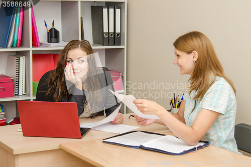 Image of Two women office workers laugh during the meeting