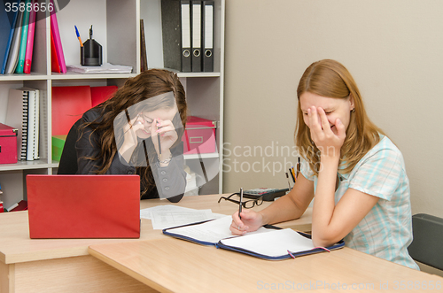 Image of Two employees of laughing at work in the office