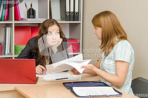 Image of A journalist and editor in the office discussing a new article