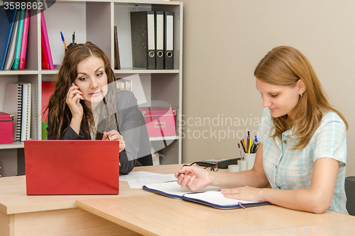 Image of Manager shocked looking at laptop and talking on a cell phone, an employee of the office wrote in a document