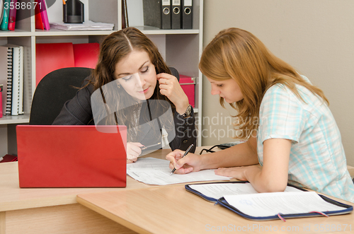 Image of Girl and specialist office editing text in a paper document