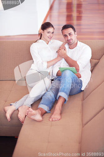 Image of couple at modern home using tablet computer