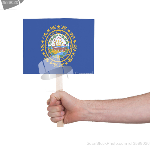 Image of Hand holding small card - Flag of New Hampshire